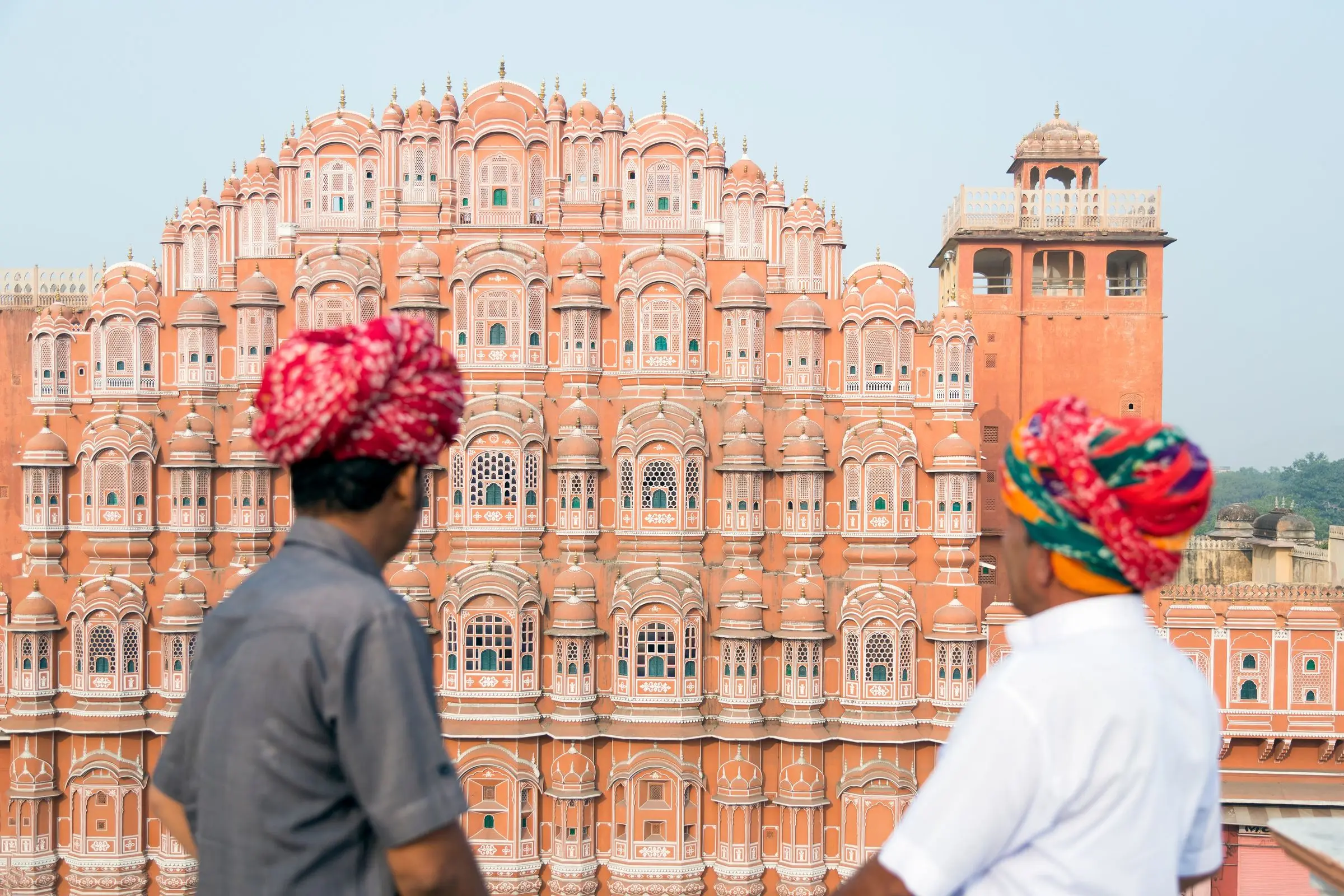 Two men in bright turbans before the pink facade of the Hawa Mahal, Jaipur