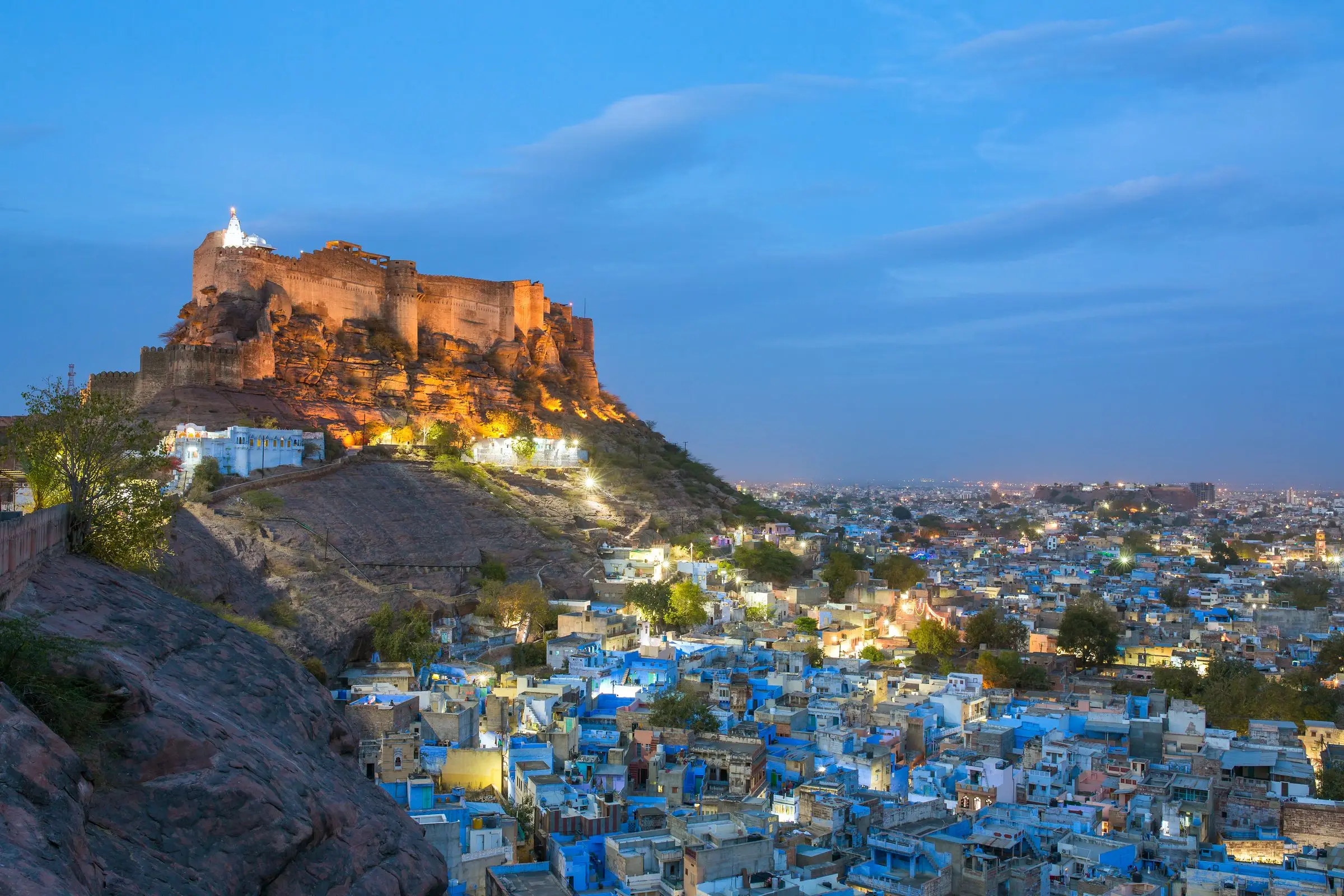 Mehrangarh Fort lit at twilight above the blue houses of Jodhpur