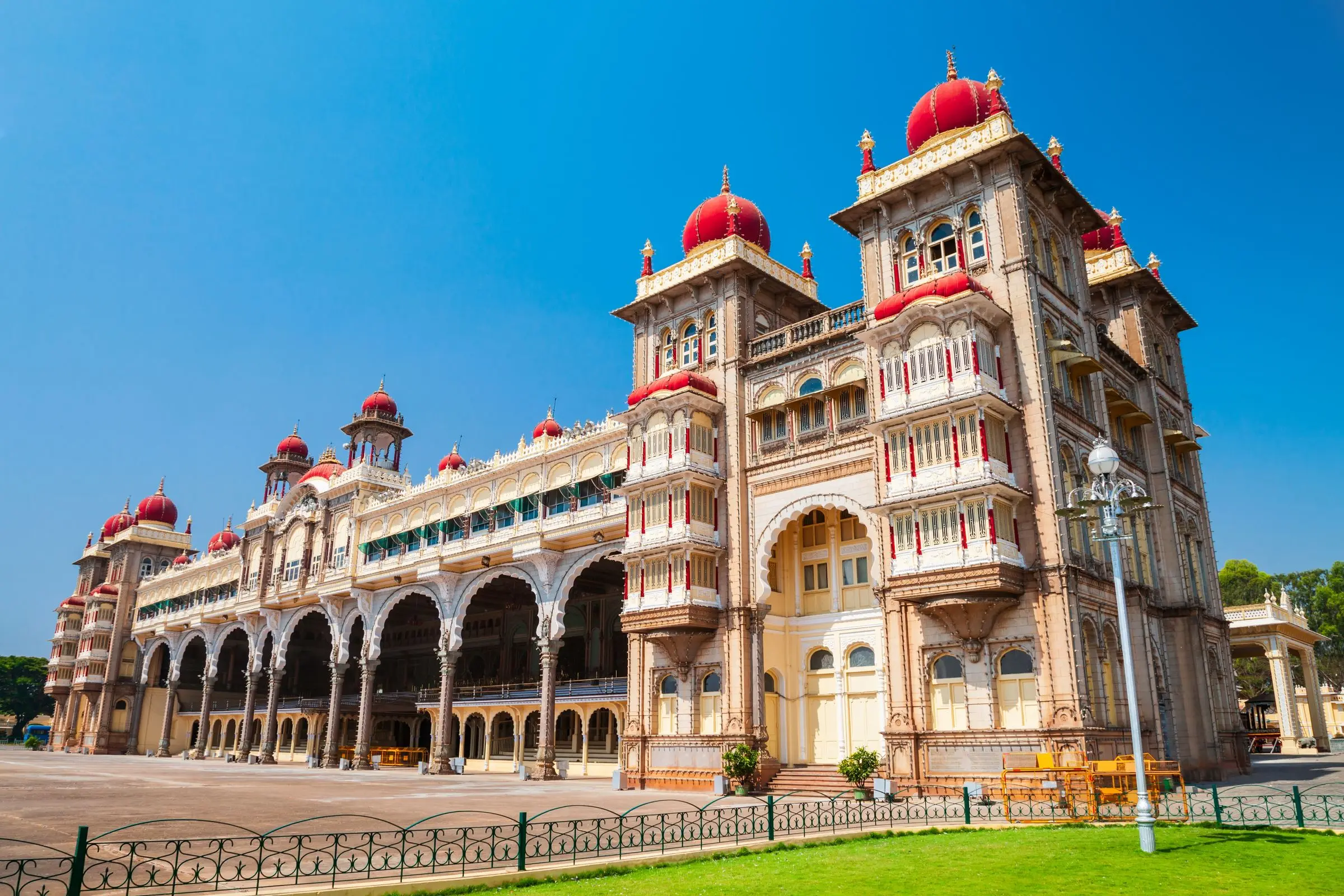 Mysore Palace with its red domes under a clear blue sky