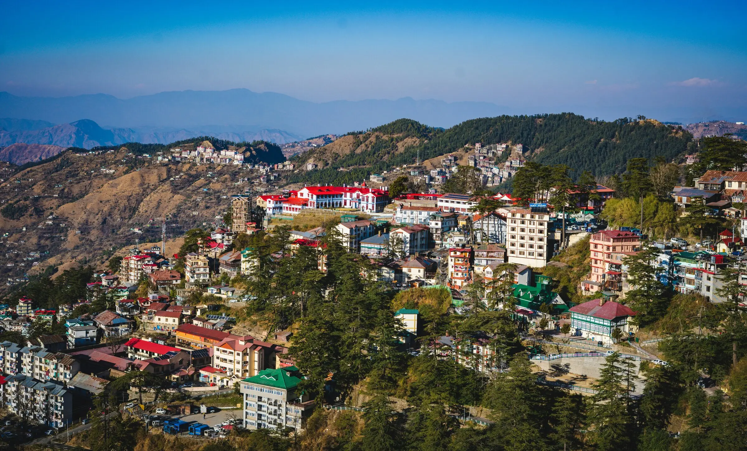 Hill station buildings terraced across a Himalayan hillside